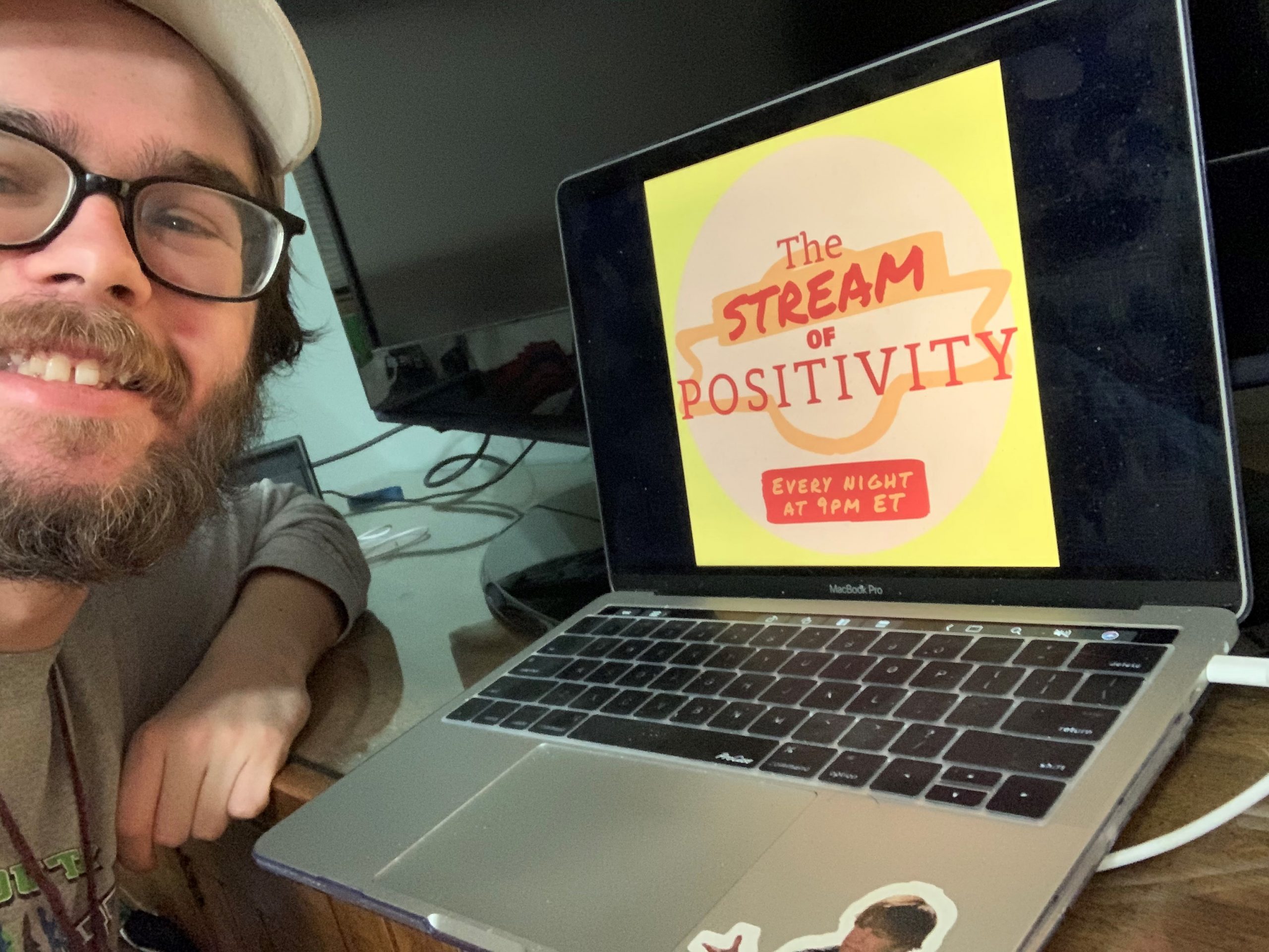 Matthew Wood sits in front of his computer at home, where the words "The Stream of Positivity" are up on the screen.