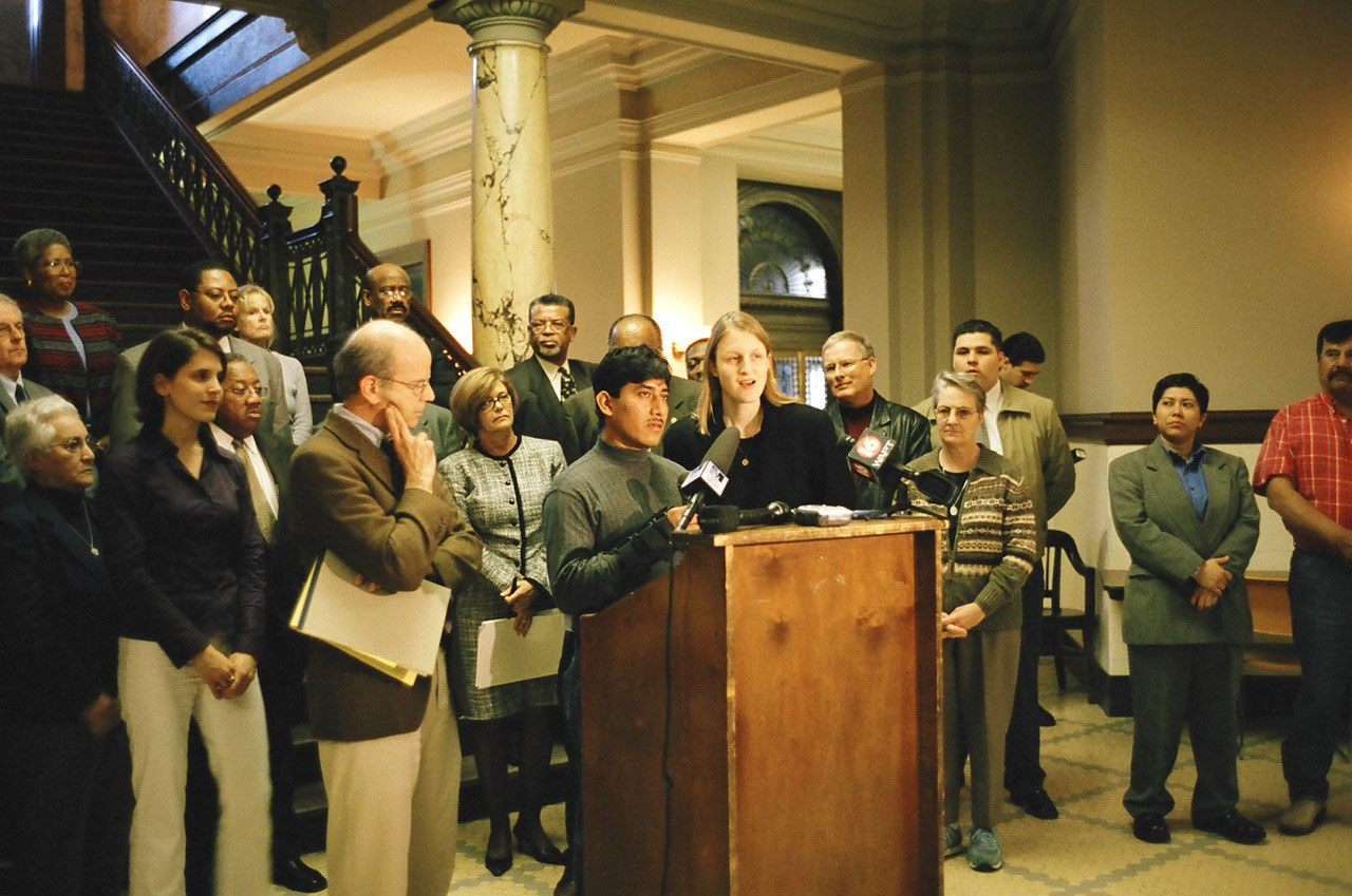 During a 2005 press conference on workers’ rights in U.S. meat and poultry plants at the Mississippi State Capitol, Stuesse interprets for injured poultry worker Israel Lucas Carbajal.