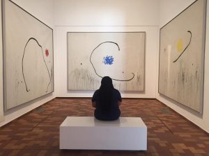 McBride in an art museum looking at three colorful art pieces