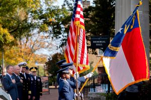 Veterans hold flags at the Veterans Day ceremony on campus.