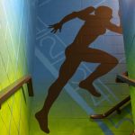 Located in Fetzer Hall, Livian Kennedy alumna's mural features five silhouetted athletes playing various sports, including basketball, swimming and tennis. A blue-green gradient — along with watermarks representing the courts and fields each of the athletes play on — sets the backdrop of the mural.