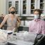 From left, graduate student Christine Mikeska and associate professor Benjamin Arbuckle pose in an archaeology lab. They are wearing masks.