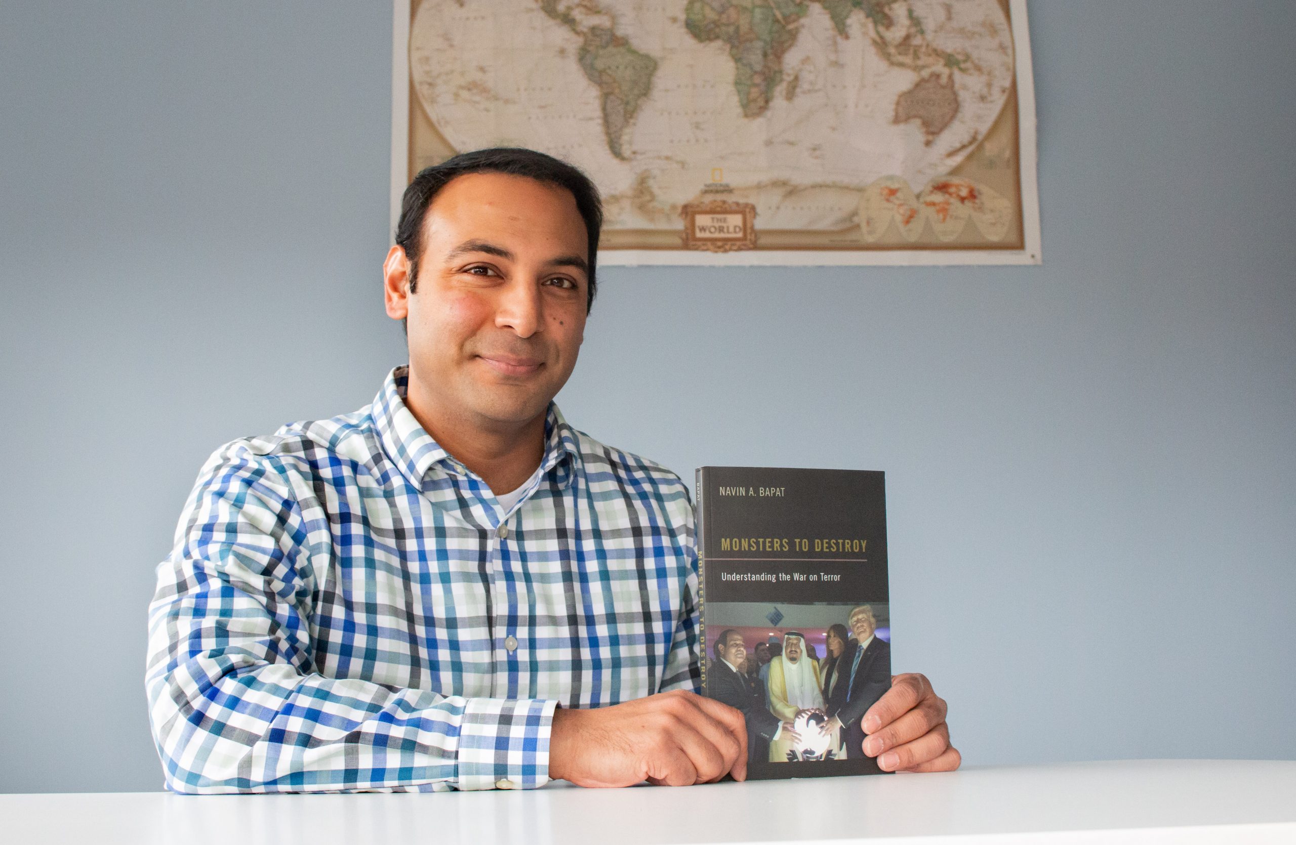 Navin Bapat holds a copy of his book, "Monsters to Destroy." (photo by Kristen Chavez)