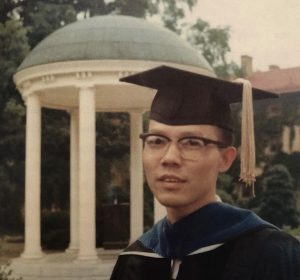 Cliff Huang poses by the Old Well to commemorate the earning of his doctorate from UNC-Chapel Hill.