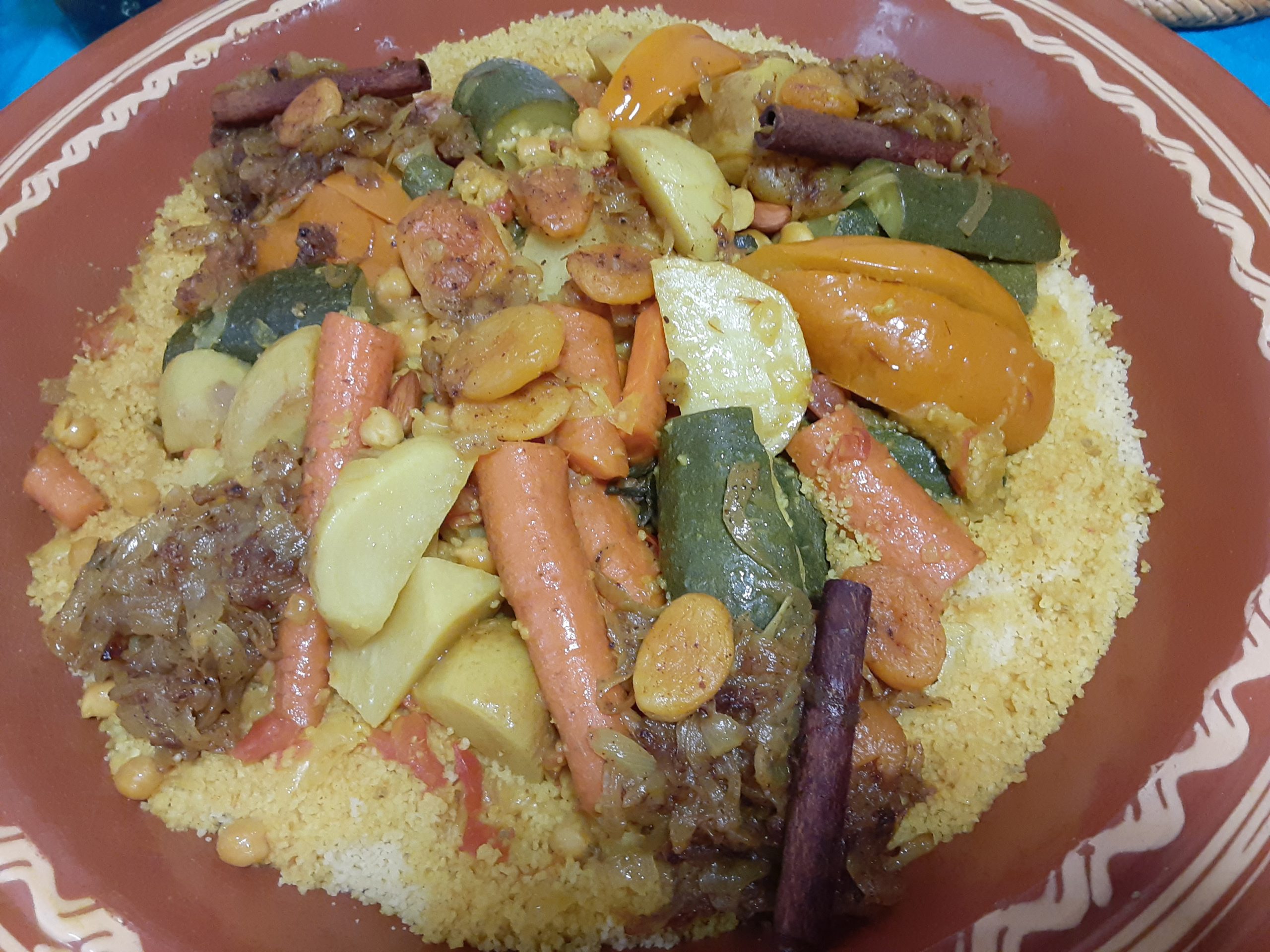 a plate of Moroccan couscous with vegetables on top