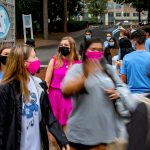 A crowd of masked students head into Kenan Stadium.