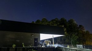 The telescope prototype sitting outside a night sky with the stars shining