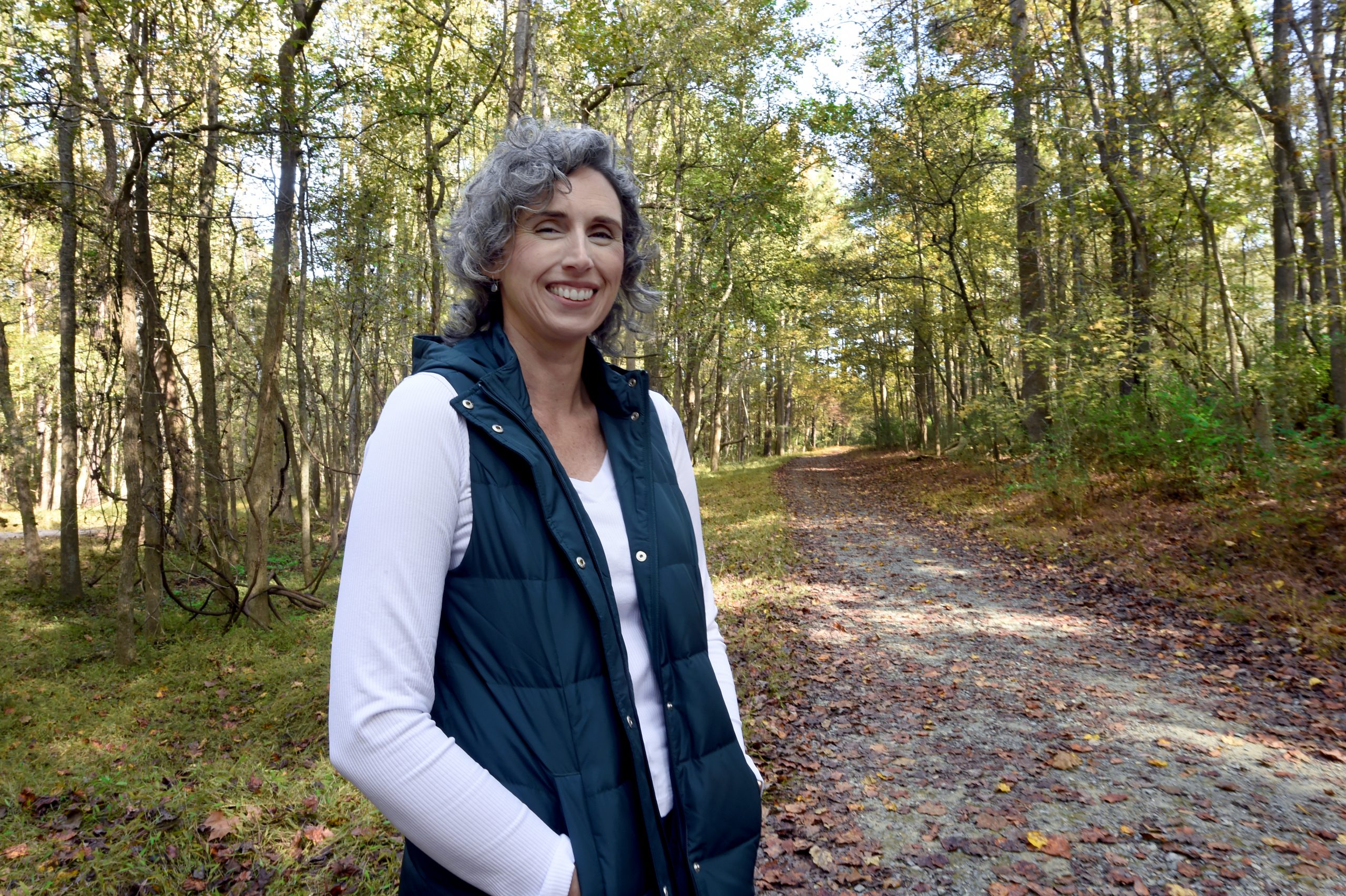 UNC archaeologist Jennifer Gates-Foster stands outside on a trail near her home.