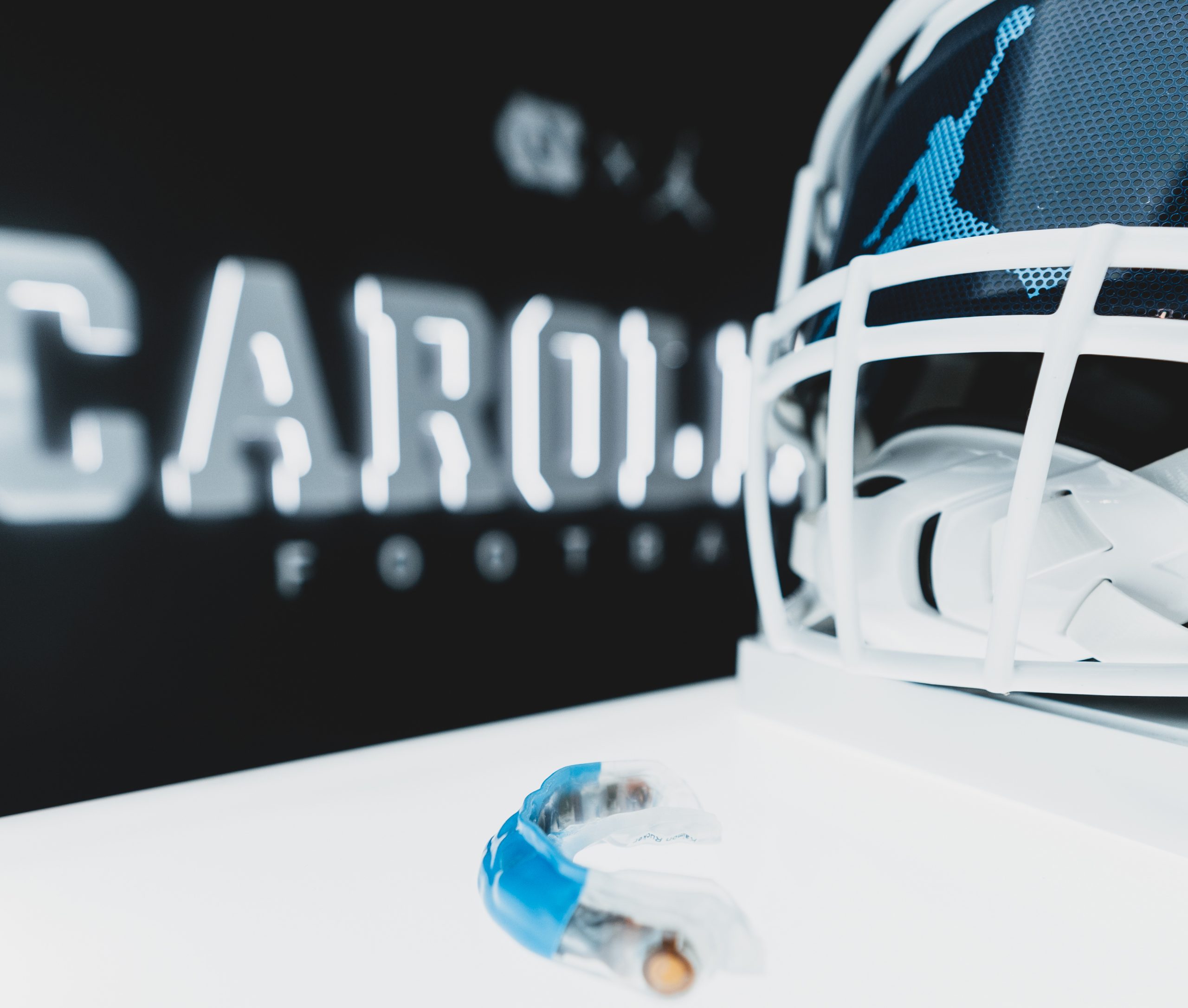photo Carolina football helmet with mouthguard in front on a table