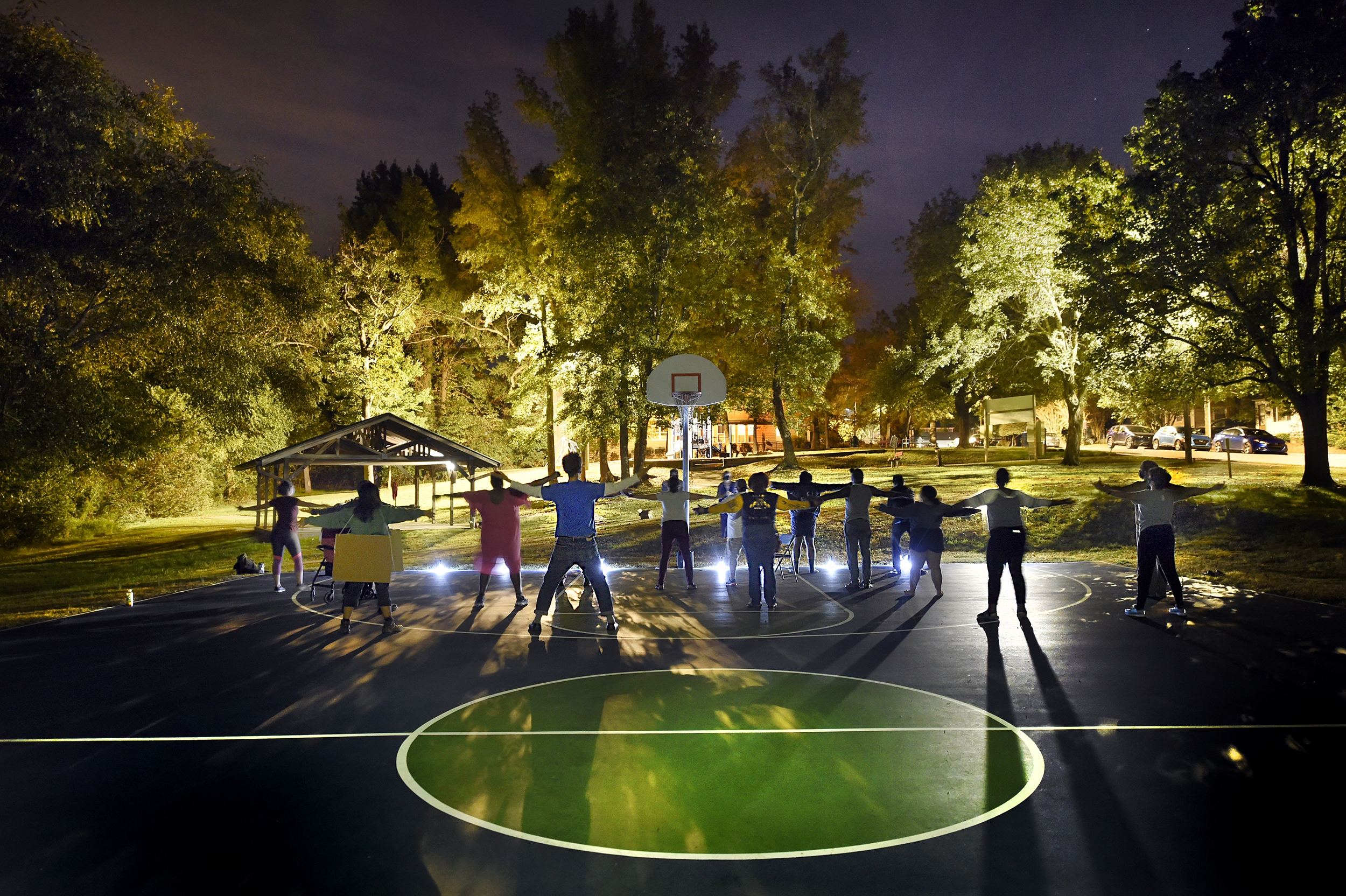 Dancers rehearse at night for "Affordable Housing: The Musical" on a local basketball court.