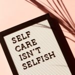 A sign says "Self Care Isn't Selfish"