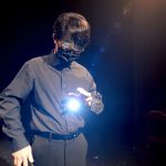 A student performing a magic trick on stage