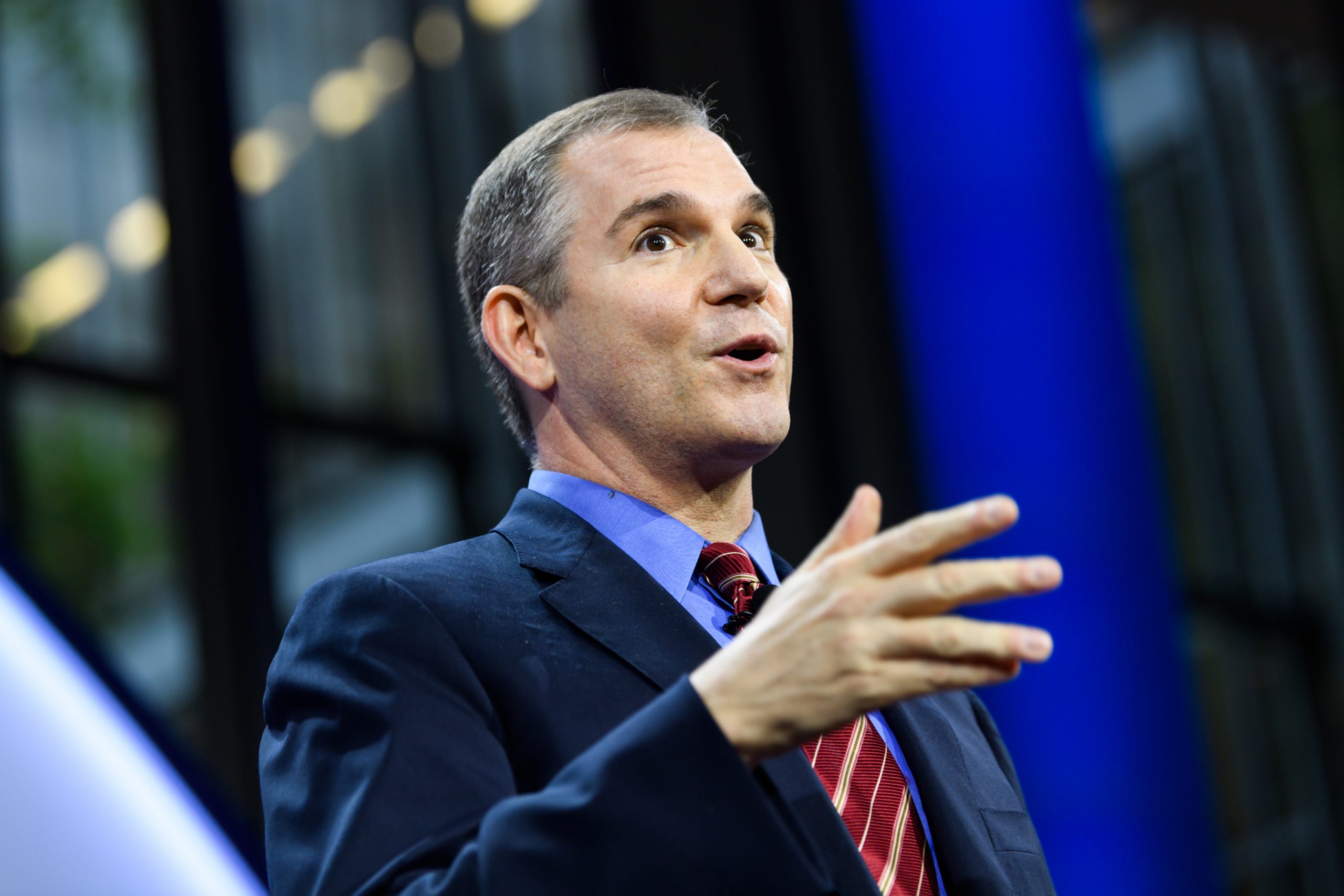 Frank Bruni speaks standing at a podium.