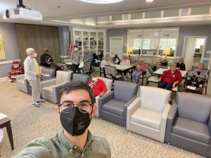 Outreach Director Michael Vazquez grabs a selfie after a meeting of Bartlett Reserve’s “Brainstorming” Philosophy Program. He stands masked in front of a group of people taking a selfie.