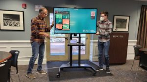 Two members set up the zoom television for a presentation