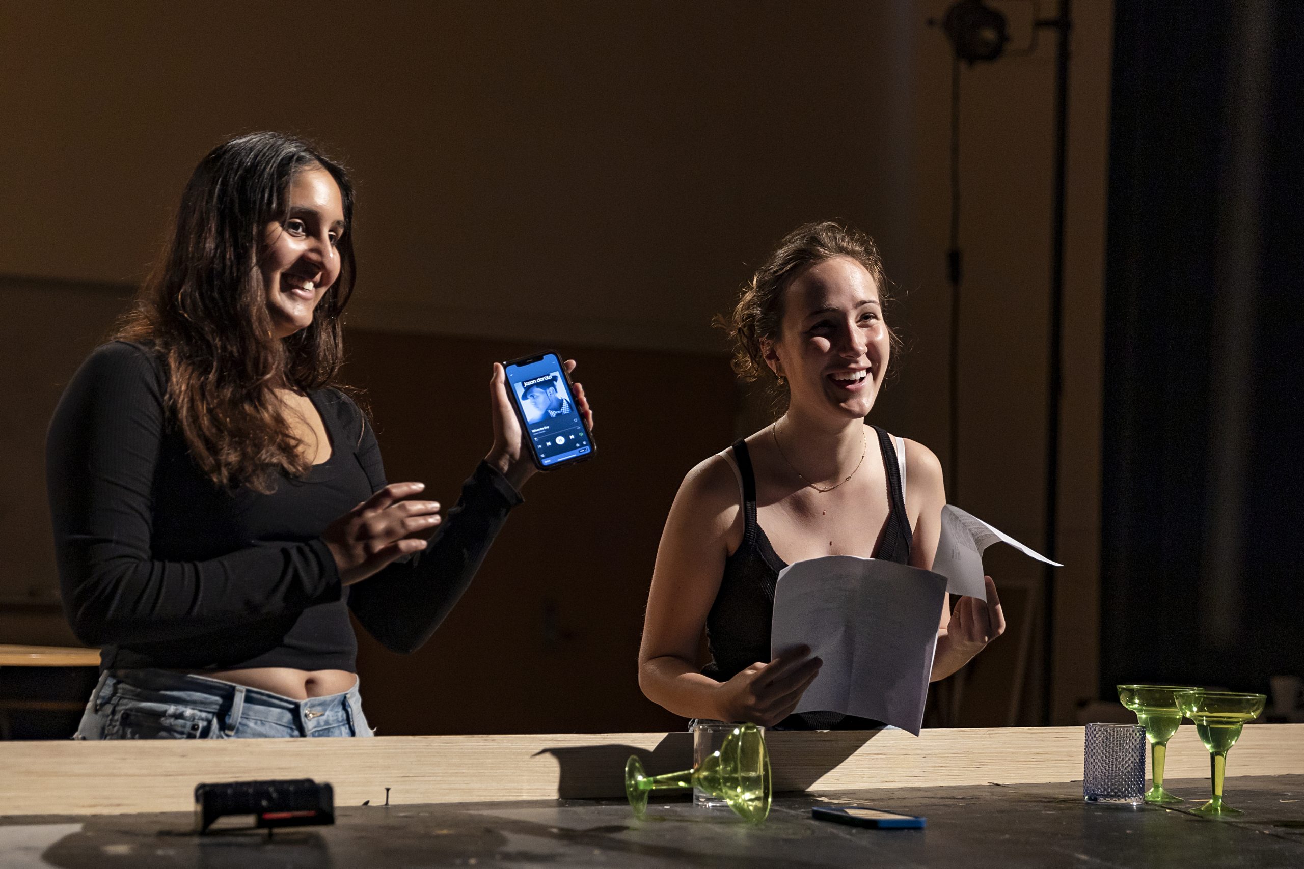 Students participate in a Maymester drama course that focused on writing half-hour comedies for television on May 25, 2022, at the Gillings Center for Dramatic Art on the campus of the University of North Carolina at Chapel Hill. In this image, (from left) junior Tara Ghorpadkar and sophomore Marion Dewey joke around after filming a scene. Ghorpadkar was the director and Dewey was the writer for the scene. (Johnny Andrews/UNC-Chapel Hill)