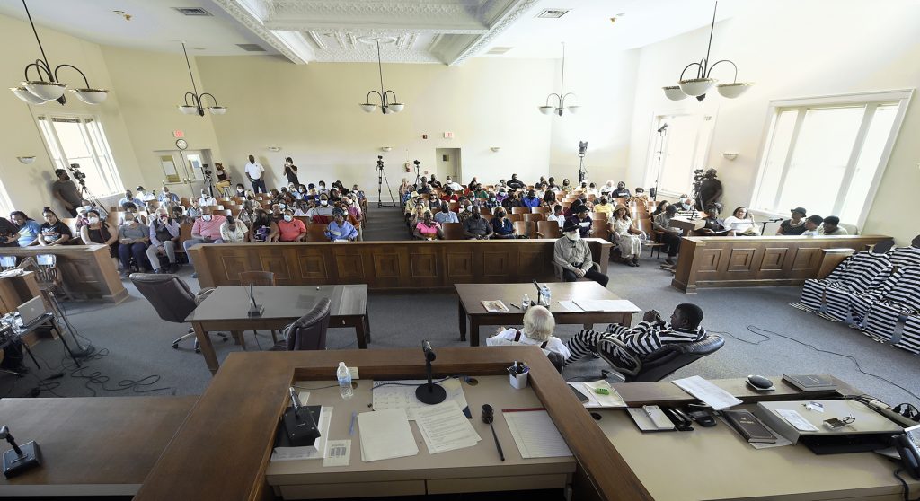 A broad view of the entire courthouse room with the actors and the audience pictured.