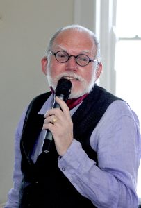 Glenn Hinson holds a microphone.