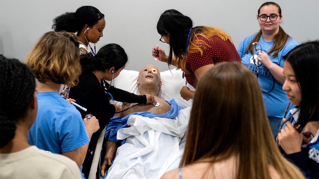 Students examine a medical school plastic human dummy as part of their program.