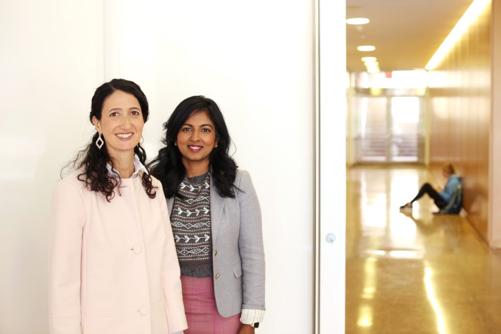 From left, Kelly Hogan and Viji Sathy stand in a classroom hallway. (photo by Travis Dove/Chronicle of Higher Education)
