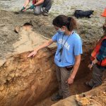 Earth, marine and environmental sciences graduate student Sarah Wells-Hull, left, puts her hand on the Little River fault after an earthquake at Sparta, North Carolina, ruptured the ground in 2020. Ashley Lynn, right, works in the trench dug to expose the fault.