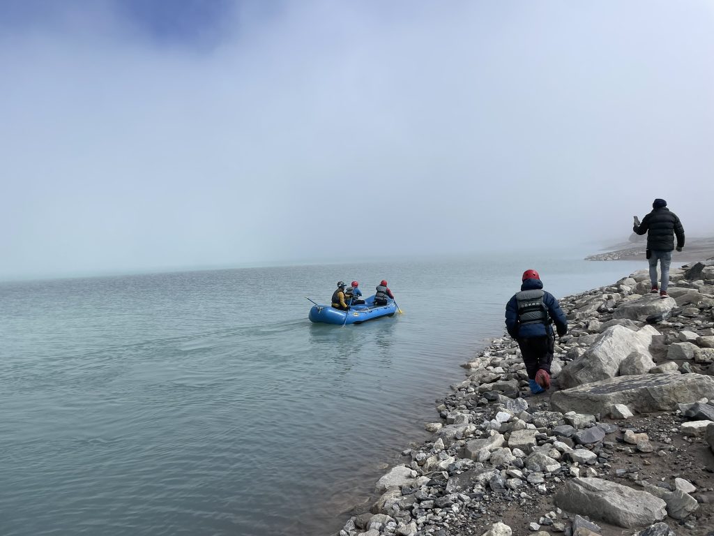 In the misty conditions the raft makes its way into the lake as people watch from the shore.