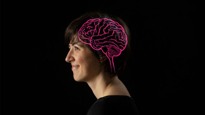 The side profile of a person with their brain outlined in glowing pink.