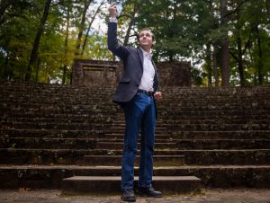Bret Devereaux stands with his right hand pointing into the air and his left as a fist at his waist, imitating the Augustus of Prima Porta statue.