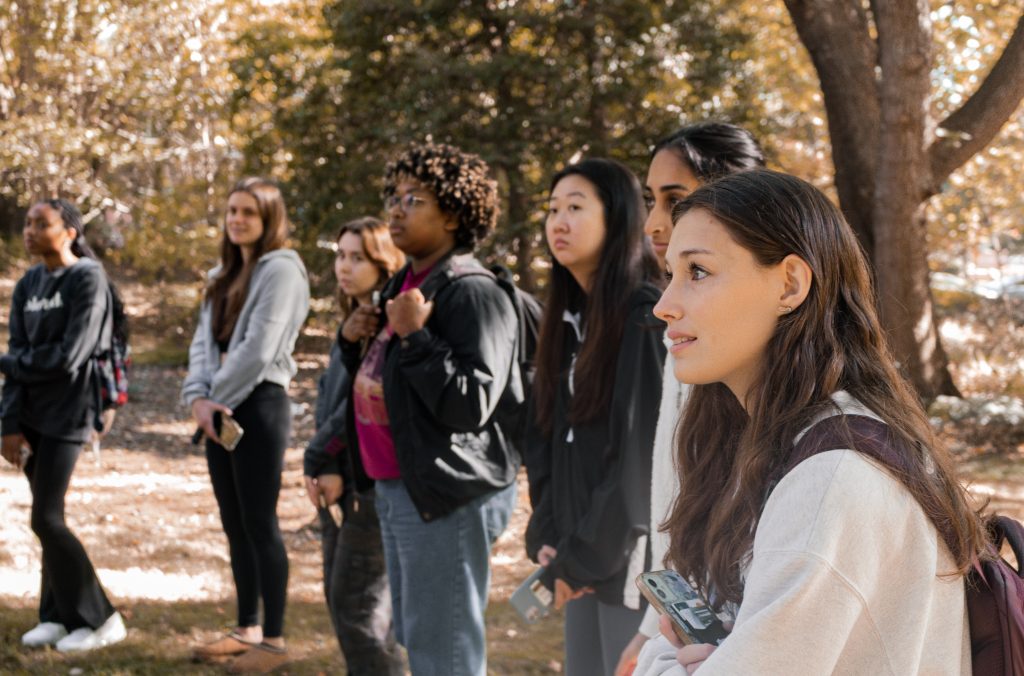 Students listen to in rapt attention to a lecture in UNC's arboretum.