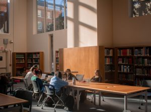 A group of students sit at a table in Davis Library, studying.