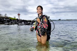 Isabel Romero stands in a body of water with her equipment.