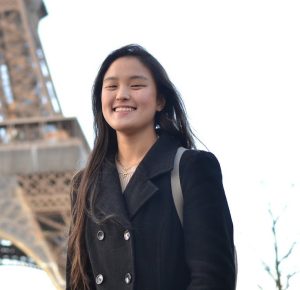 Emma Zhang stands in front of the Eiffel Tower.