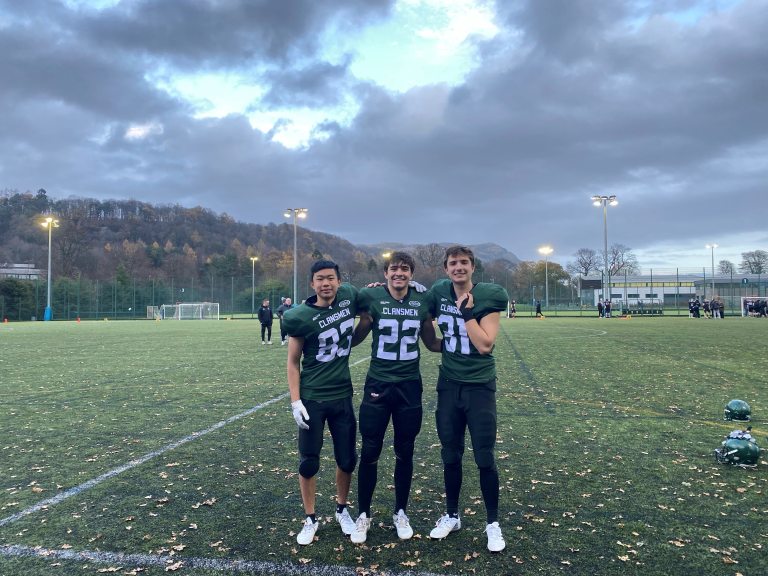 Jackson Holmes and two other students in football uniforms.