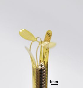 Medical robot inside catheter, yellow with metal interior.