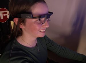 A person wearing eye-tracking technology, a device worn around their forehead