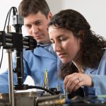 : Taylor S. Teitsworth (with James Cahoon, left) uses a cryogenic probe station, which allows her to perform electrical measurements on semiconductor nanowire materials at very low temperatures.