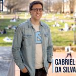 Waist-up shot of Gabriel Bernardo da Silva, UNC’s campus out of focus in the background. Features the words “#GDTBATH” and da Silva’s name.