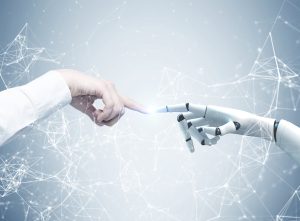 Human and robot hands reaching out and touching with index fingers. A gray background with a network hologram.