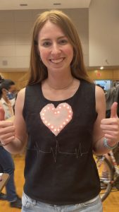Charlotte Dorn wearing a black vest adorned with a lit-up heart and depiction of heart rate.