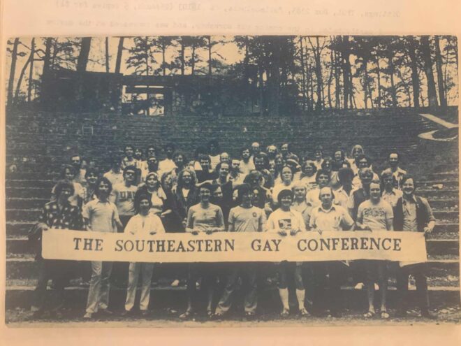 (Sepia-toned, black-and-white) Large group of people holding a banner that says "The Southeastern Gay Conference" at the bottom of the stone steps in the Forest Theater.