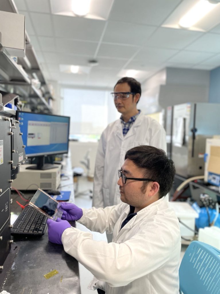 Jinsong Huang and Chengbin Fei work together in the lab.