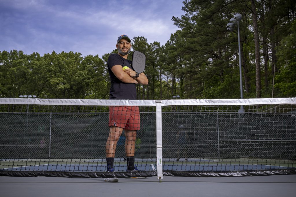 Esteban Agudo poses with racket in hand on the pickleball court.
