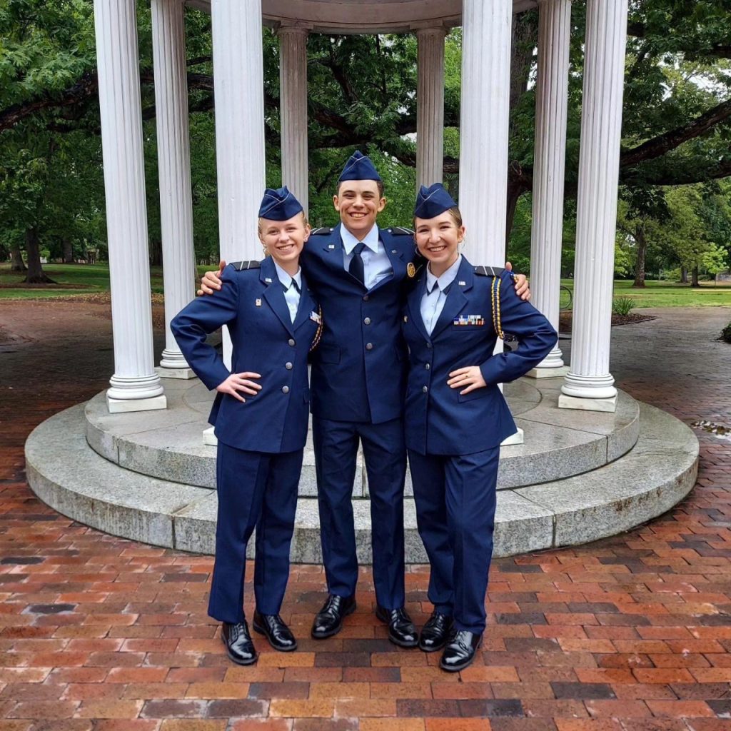 The cadets stand in their dress blues uniforms in front of the Old Well.