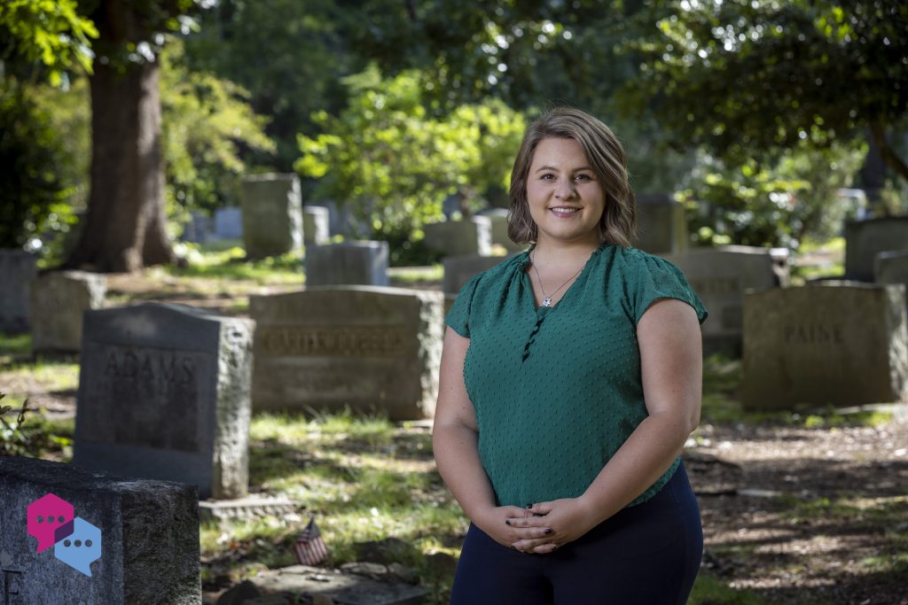Alison Curry poses outside in a cemetery.