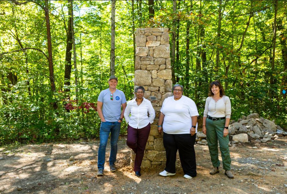 Catawba Vale Collaborative members stand together in front of a stone pillar.