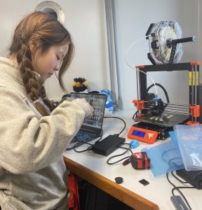 Lilia Su works at a 3D printer station.