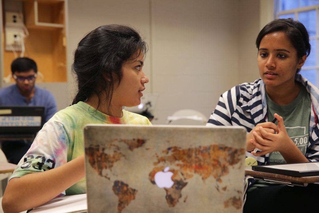 A student learns from a peer tutor at the Writing and Learning Center. A laptop sits in front of them during the tutoring session.