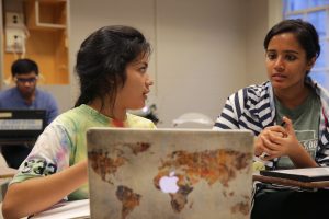 A student learns from a peer tutor at the Writing and Learning Center. In front of them sits a laptop during their tutoring session.