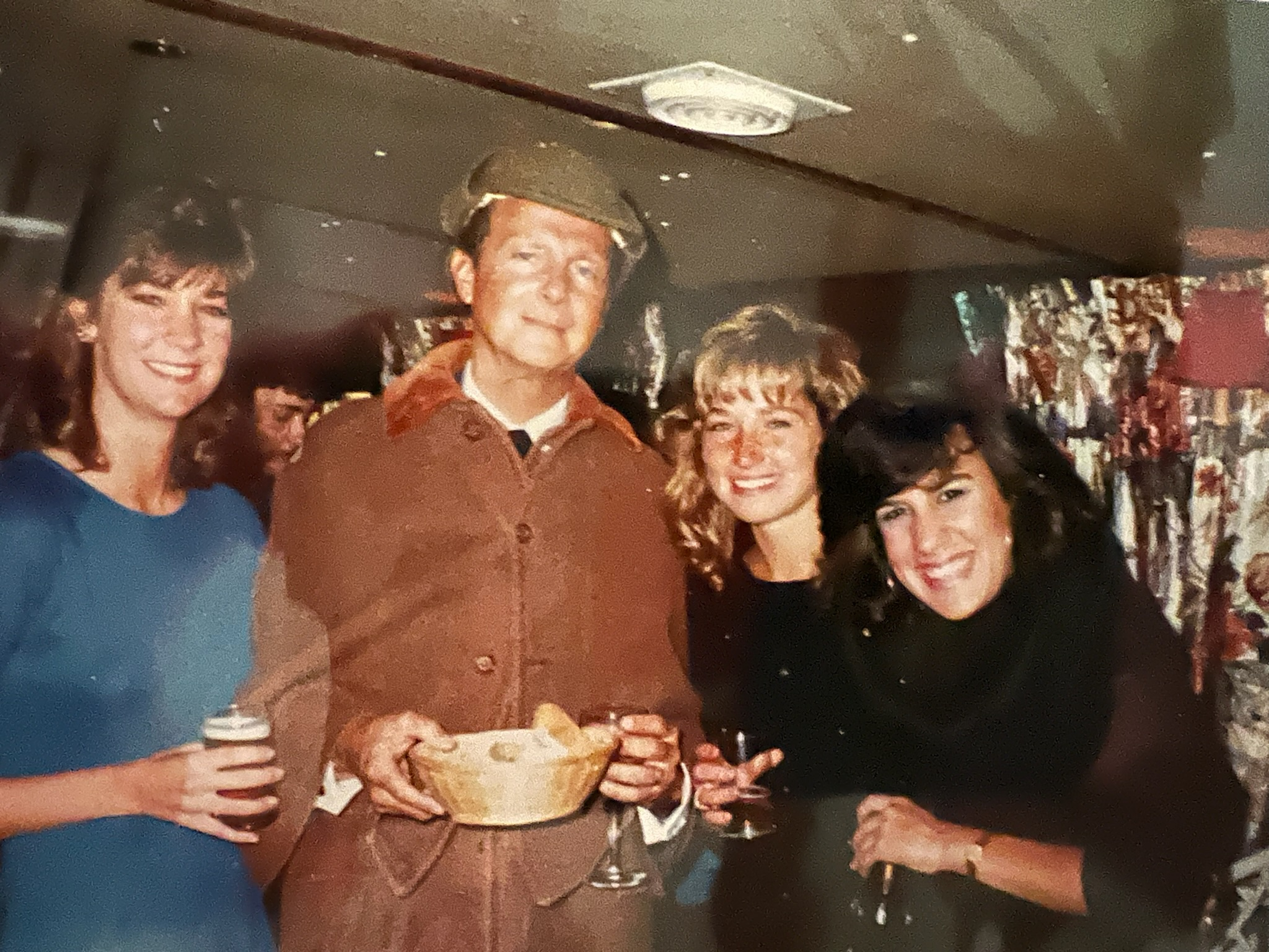 A color photo of Kimball King surrounded by female students at a London outing.
