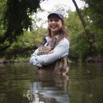 Julianne Davis stands in a river in waders